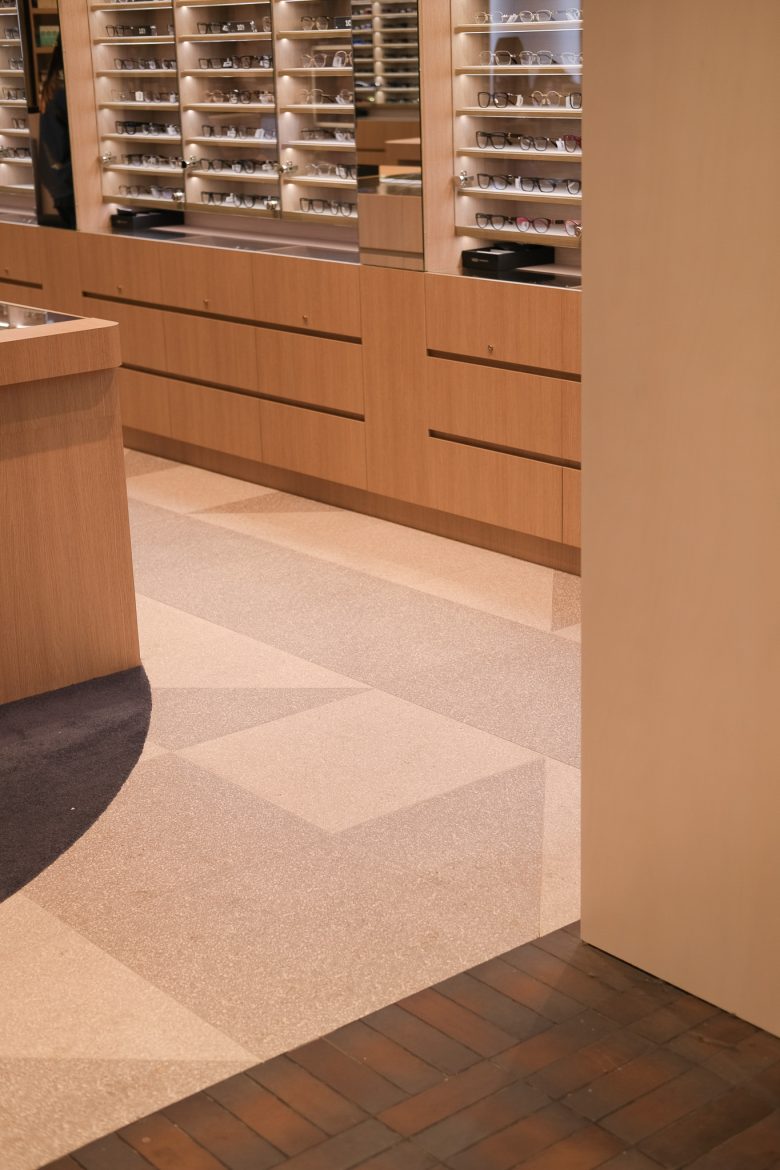 Стеллажи с оправами и деревянные тумбы, геометрический пол 1001 Optometry store design