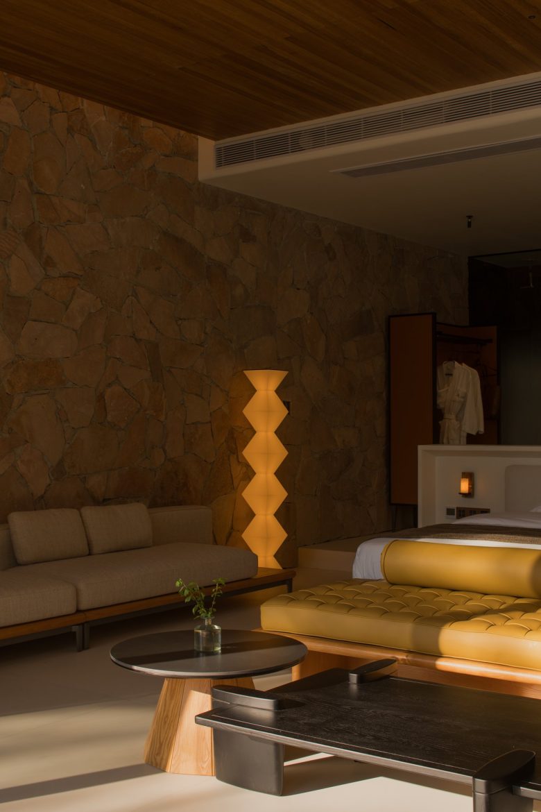 Номер-сьют с каменной стеной, диваном и кроватью с желтой банкеткой ALAN RESORT