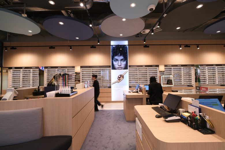 Торговый зал оптики с островными стойками и стенами с оправами 1001 Optometry store design
