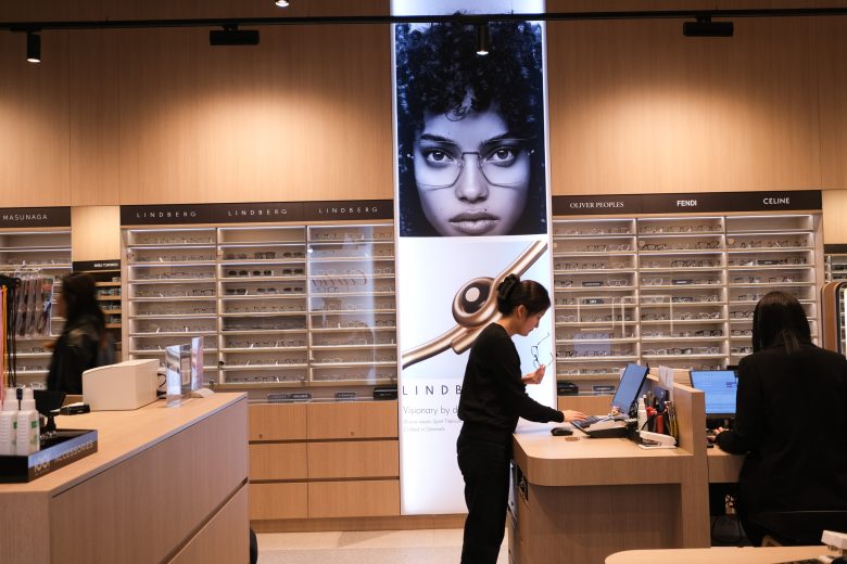 Кассовая стойка и световая панель с моделью в очках 1001 Optometry store design