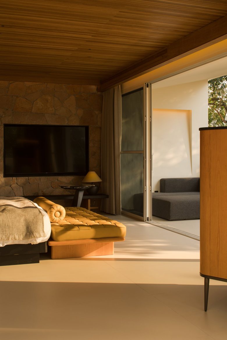 Спальня с ТВ на каменной стене и раздвижными дверями в гостиную ALAN RESORT