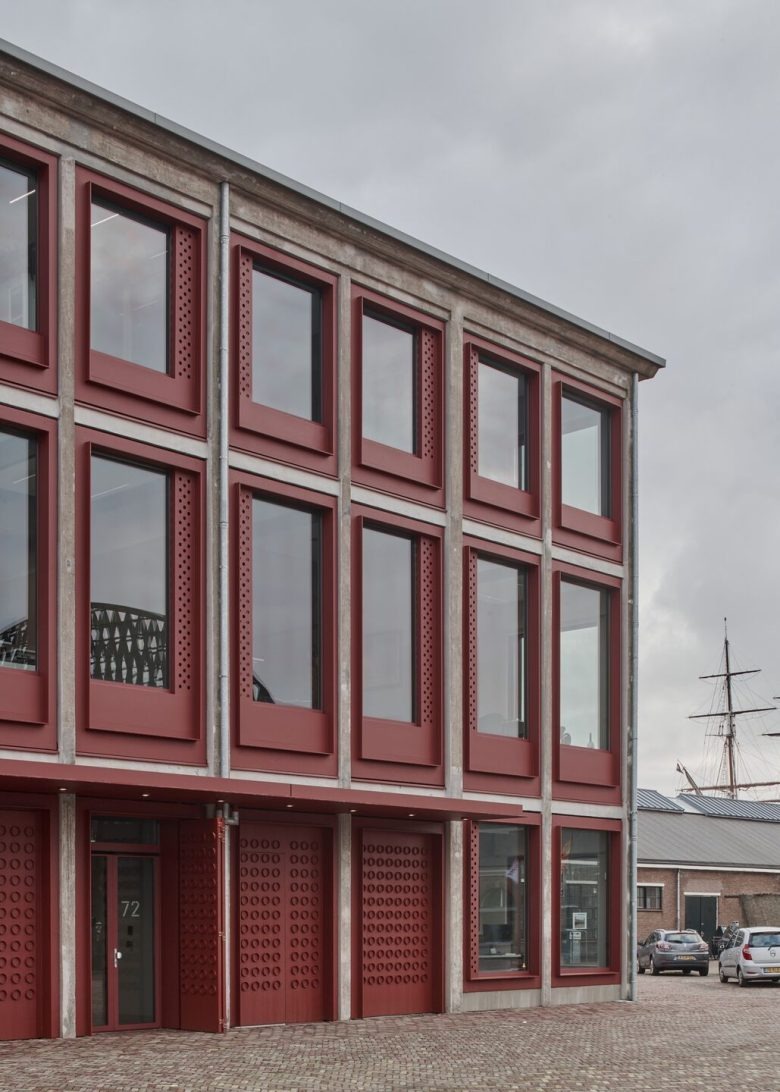 Фасад здания с красными оконными рамами Den Helder City Hall