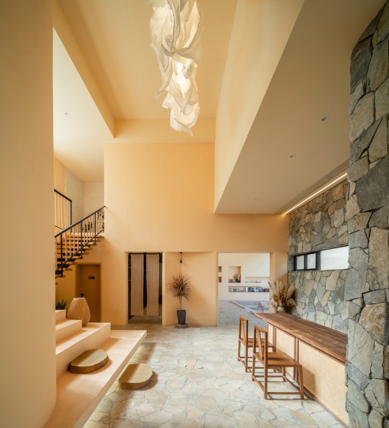 Интерьер холла с лестницей и каменной стеной Sounder Inn