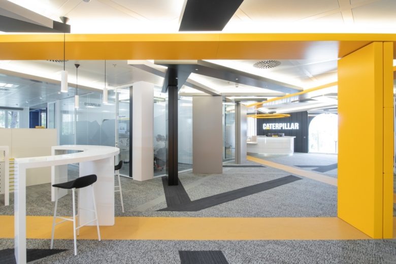 Интерьер офиса с желтыми архитектурными элементами Caterpillar Offices