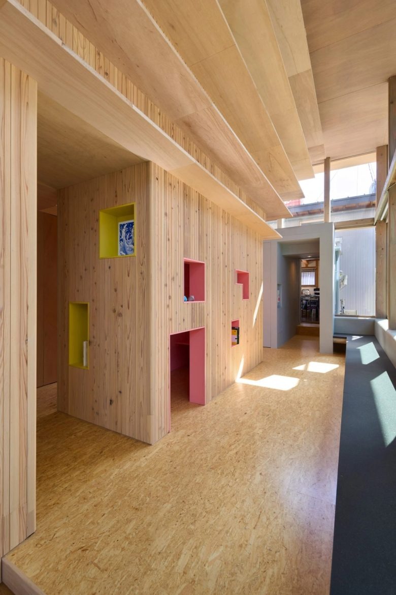 Интерьер с деревянной стеной и игровыми нишами Umedacho Community Centre