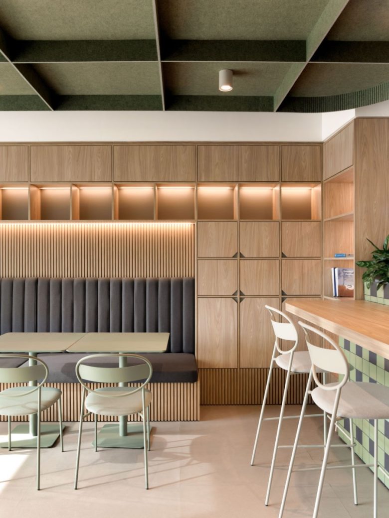 Кафе-зона с деревянными шкафами, мягкой банкеткой и подсветкой ниш Yves Rocher offices