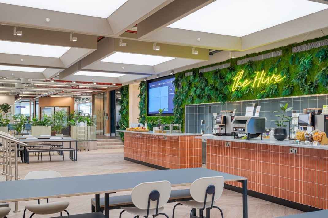 Кафетерий с неоновой вывеской и зелеными насаждениями Landsec headquarters