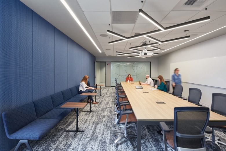 Конференц-зал с длинным столом, проектором и синей стеной Office