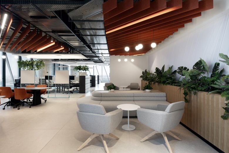 Лаунж-зона с мягкой мебелью и зелеными растениями в офисе Hewlett Packard Enterprise offices