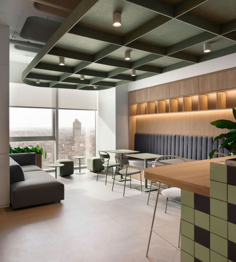 Лаунж-зона у окна с диваном, столиками и решетчатым потолком Yves Rocher offices