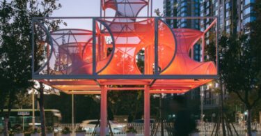 Общий вечерний вид павильона среди деревьев Curly Cube