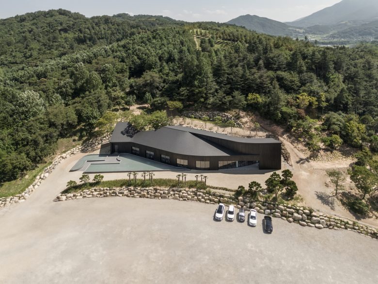 Общий вид здания среди лесного ландшафта Tan Mok Won