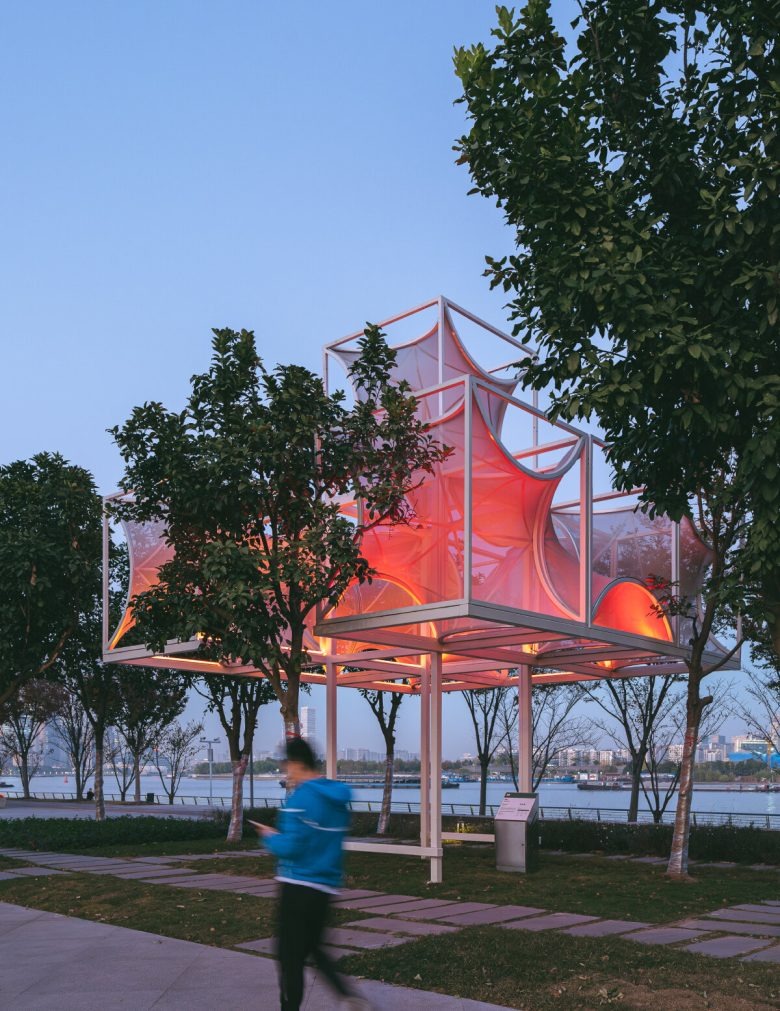 Павильон с красной подсветкой среди деревьев вечером Curly Cube