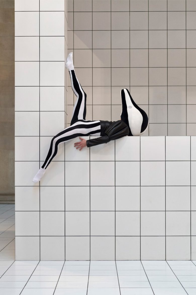 Перформанс с телом в полосатом костюме на стене инсталляции Tate Britain Exhibition