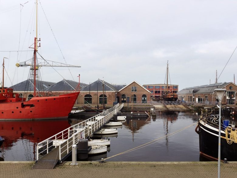 Портовая зона с кораблями и мостиком Den Helder City Hall
