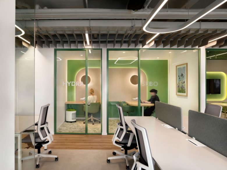 Рабочие места и две стеклянные переговорные с зелеными стенами Yves Rocher offices