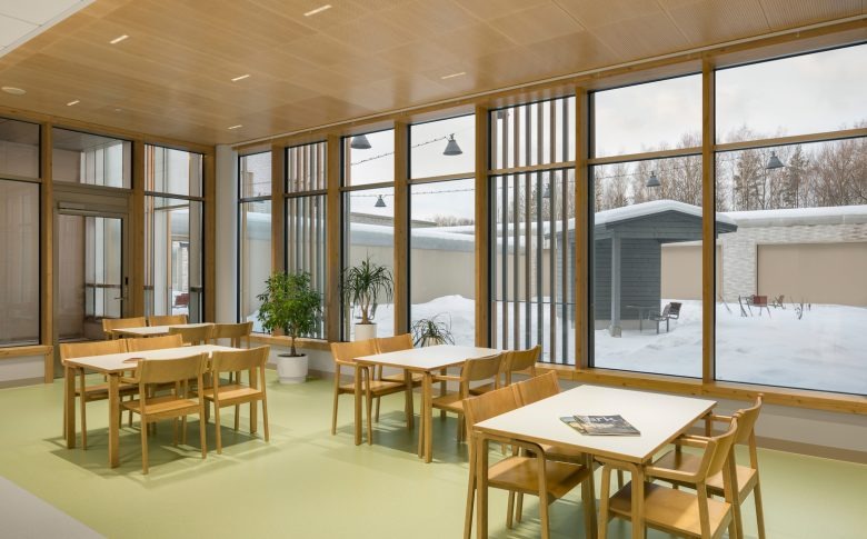 Столовая зона с деревянной мебелью и панорамными окнами Tampere Psychiatric Clinic