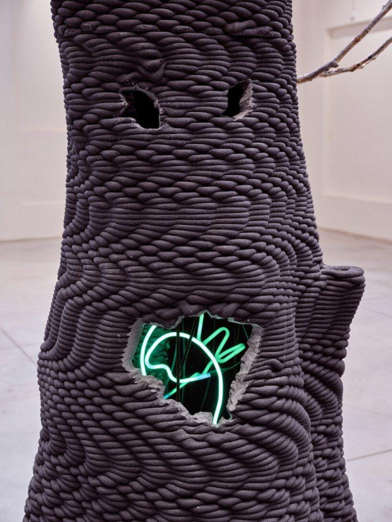 Темная текстурная скульптура с неоновой фигурой The Virtues and Vices of Our Time installation