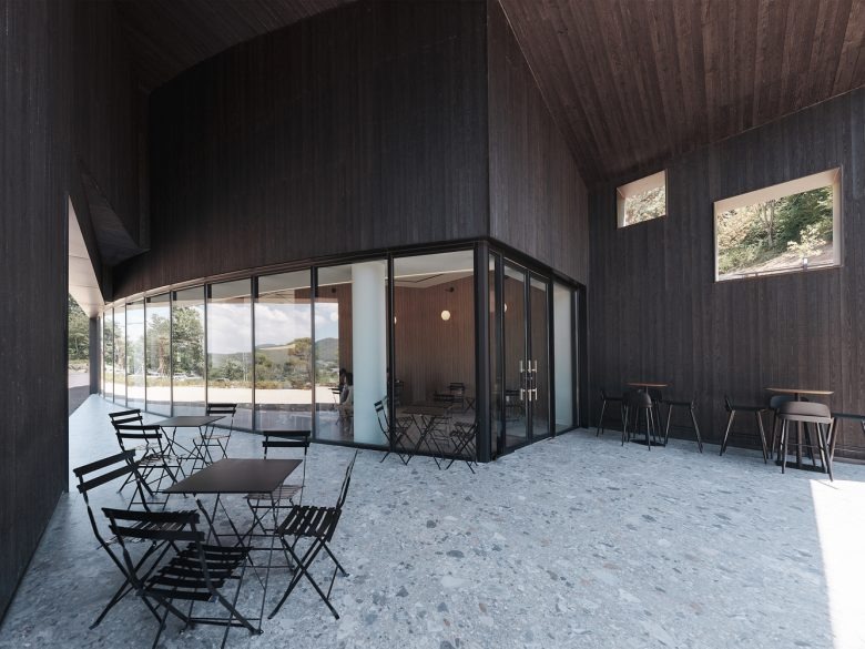 Терраса с уличными столиками у стеклянного фасада Tan Mok Won