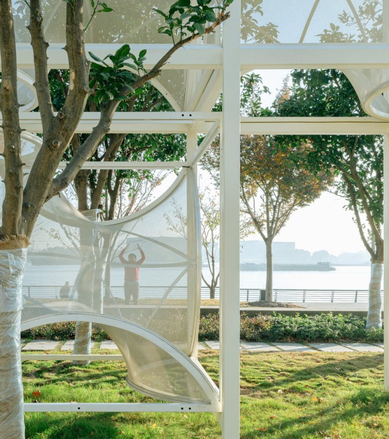 Вид изнутри павильона на набережную и деревья Curly Cube