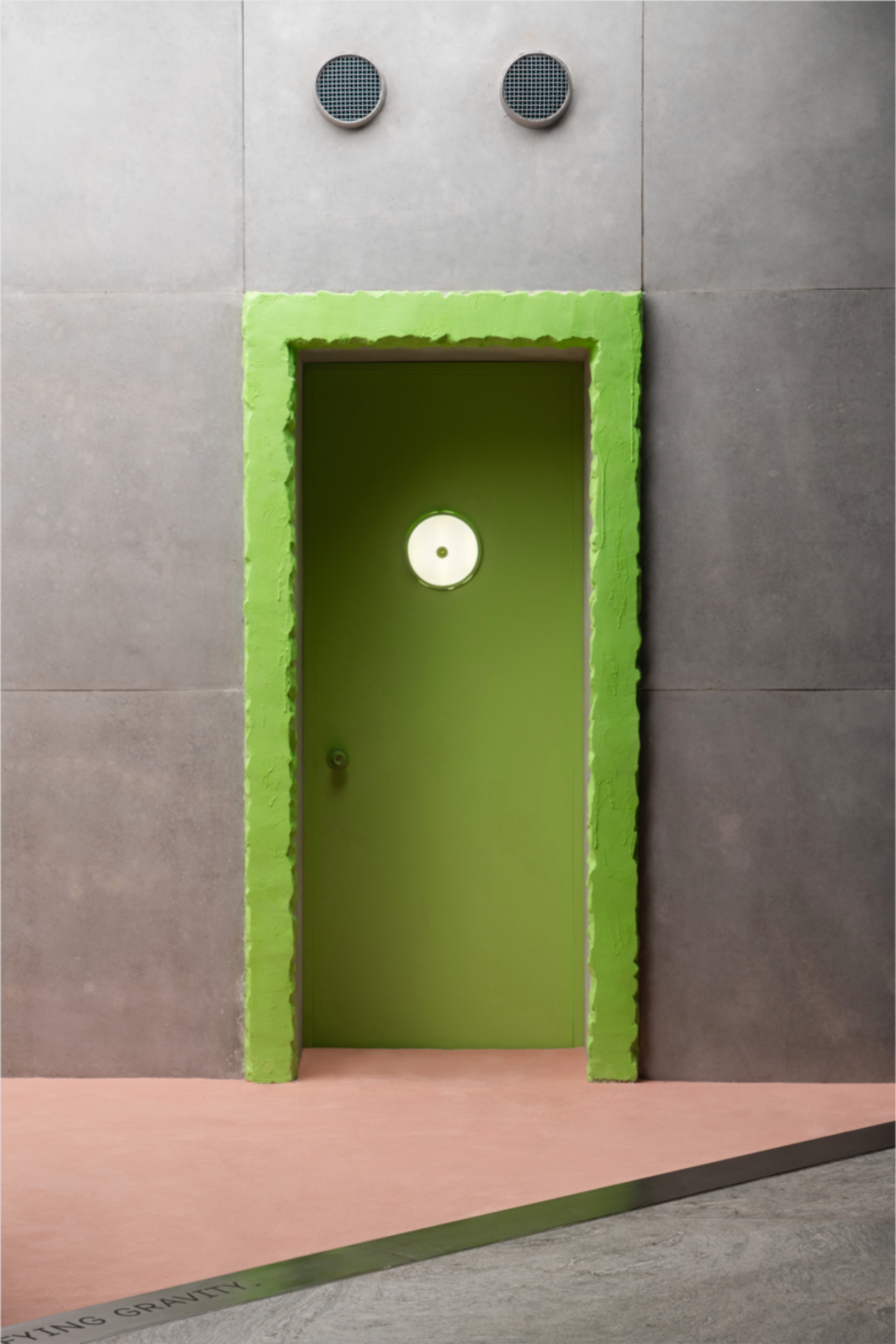Зеленая дверь в бетонной стене с подсветкой Donut of Curiosity store