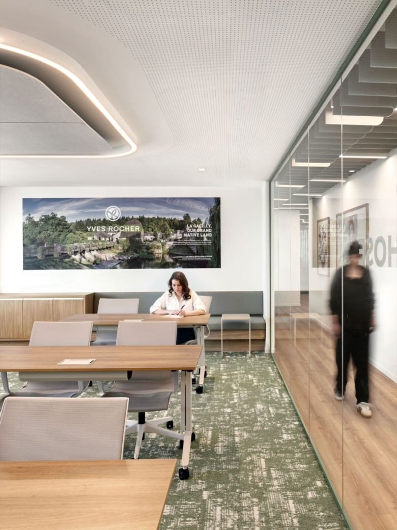 Зона для работы и отдыха с банкеткой и большим брендовым панно Yves Rocher offices