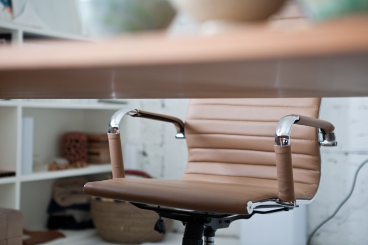 Кожаный стул коричневого цвета в интерьере маленького офиса
