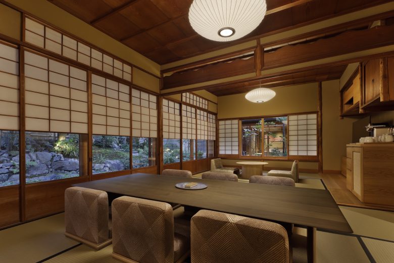комната со столом и креслами на полу Hotel VMG Villa Kyoto