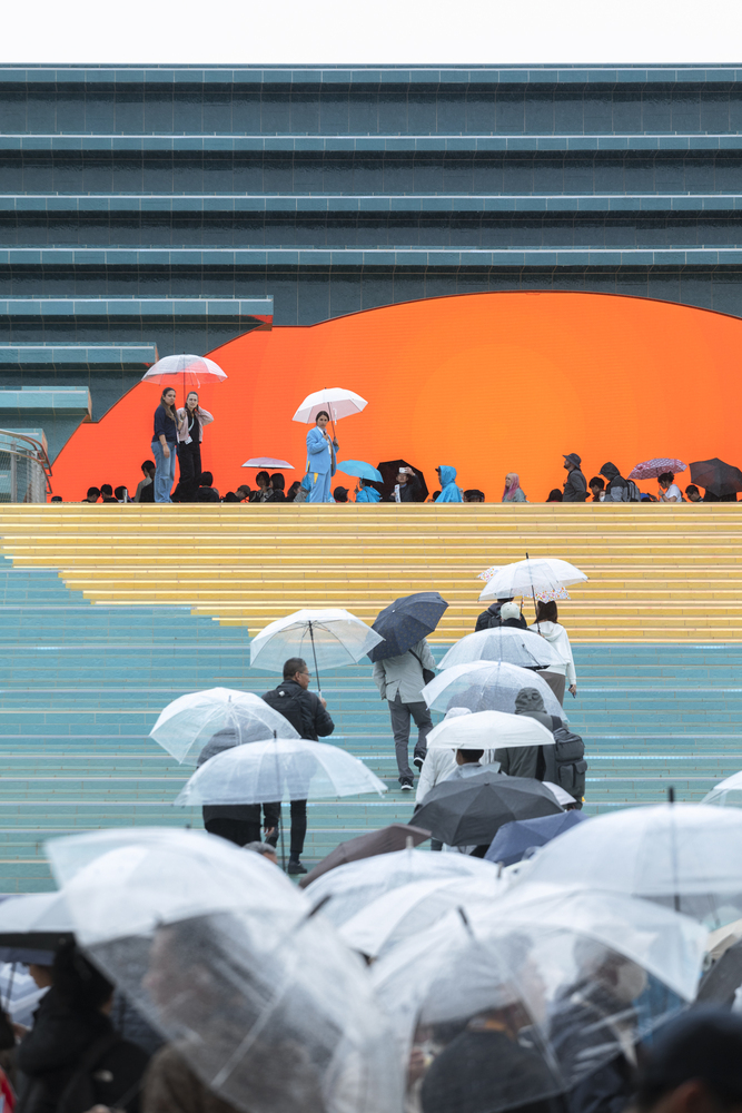 люди с зонтиками на лестнице Spanish Pavilion at Expo Osaka 2025