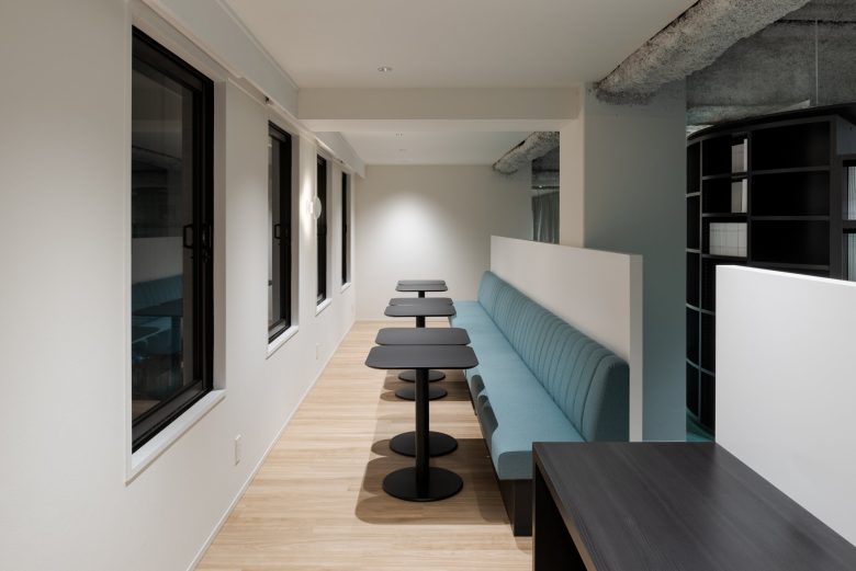 рабочее пространство с длинным диваном и столиками Adal Creative Place в Осаке